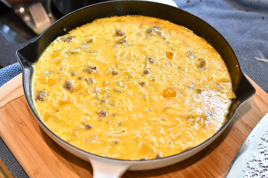 Photo of sausage and pepper frittata in Staub cast iron pan. 