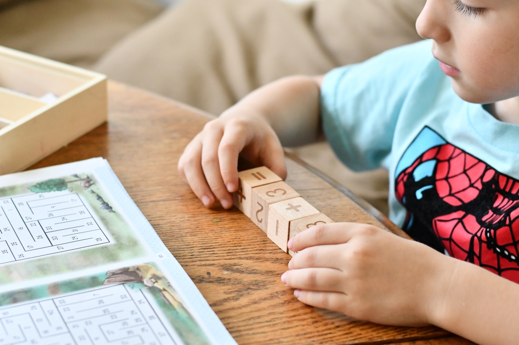 Child using math manipulatives from The Good and The Beautiful Homeschool Curriculum